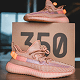 pair of sneakers in peach color placed on a branded box